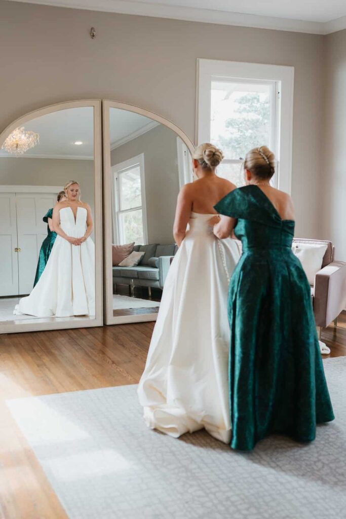 mother of bride helping bride get dressed at vanlandingham estate