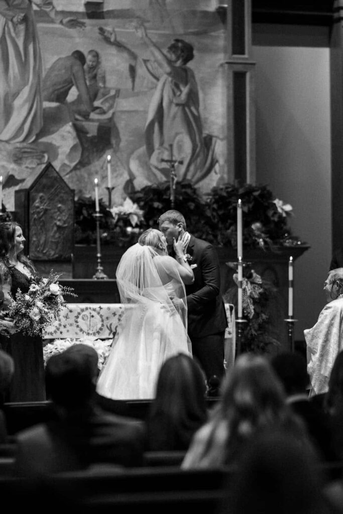 bride and groom first kiss wedding ceremony at st peters catholic church charlotte, nc